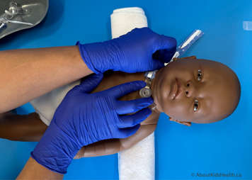 Holding tracheostomy tie on one side while preparing to resecure it