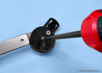 Tightening the top screw on the bar using a screwdriver