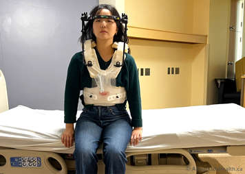 Sitting up on a bed while wearing a halo vest device