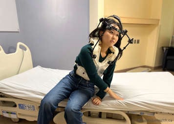 Midway to pushing up from a bed while wearing a halo vest device