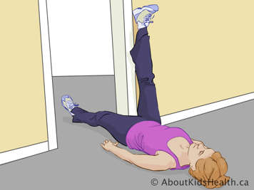 Woman on her back with one leg lifted against a wall and the other leg stretched straight along the floor through a doorway