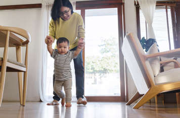 Mom helping baby learn to walk