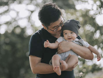 Father carrying baby facing outwards