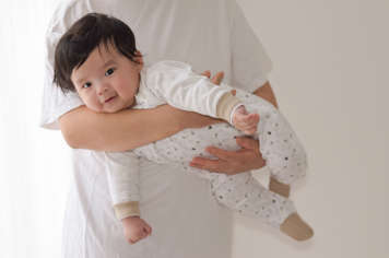 Parent with baby showing tummy time carry