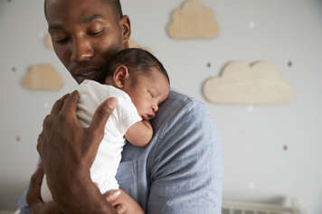 Father carrying child on his chest