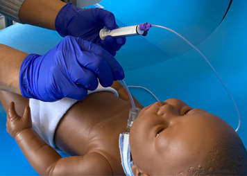 Feeding tube that is being used for manual suctioning being guided into child