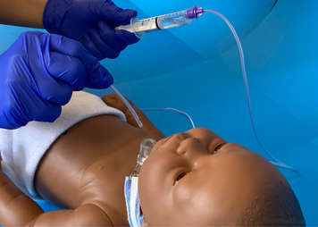 Removing the feeding tube that is being used to manually suction from the child