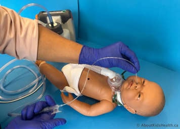 Suction catheter being inserted into child's nostril while leaving the suction port uncovered