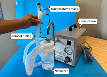 Heavy-duty compressor with water bottle and corrugated tubing connected to a tracheostomy mask