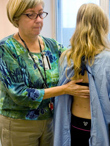 A nurse checking a patient's back