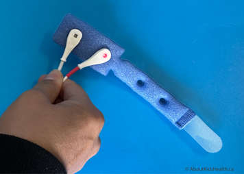 A reusable Y-sensor probe with foam wrap showing the dark blue side of the foam wrap with the probes in place