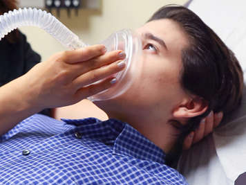 Child wearing cough assist machine mask.