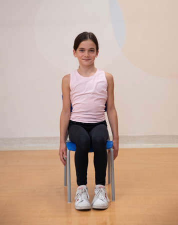 girl sitting in chair with shoulders down