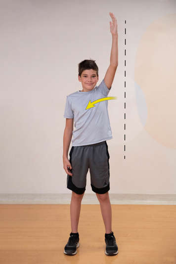 Boy standing with right arm raised