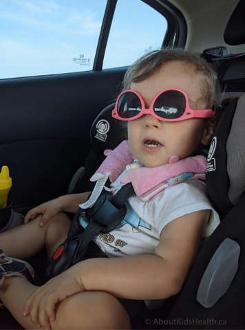 Child with a tracheostomy sitting in a car in a car seat